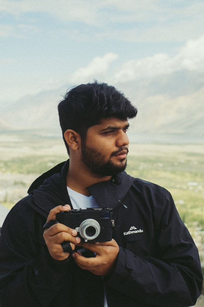 Shivam Pandey holding a camera and looking to his left.